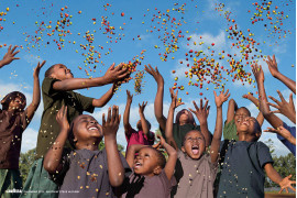 Kalendarz Lavazza 2015, fot. Steve McCurry, dzieci w Szkole Ojca Piotra w Tanzanii symbolizują Obrońców Ziemi przyszłości. Rzucając kolorowe ziarna kawy w powietrze wskazują na to, że przyszłość naprawdę leży w naszych dłoniach.