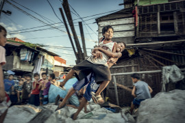 fot. Bernard Kwapiński, "Happyland", Manila, Filipiny<br></br><br></br>W 1995 roku władze Manili zamknęły przepełnione wysypisko śmieci, a pracujących tam ludzi przeniesiono na kawałek ziemi, który był składowiskiem odpadów żywności. Choć pozwolono zostać im jedynie na chwilę, nie opuścili tego miejsca i stworzyli jeden z największych slumsów, dający dzisiaj schronienie ponad 30. tysiącom mieszkańców. HAPPYLAND – ta oficjalna nazwa, powstała ze spontanicznie wymienionych liter w nazwie HAPILAN pochodzącej z lokalnego dialektu Visaian, a która w oryginale określała to miejsce jako ziemię cuchnącą. Historia jest zapisem zjawisk, które uznałem za najbardziej przejmujące, szczególnie tych, związanych z żyjącymi w tym nieszczęściu dziećmi.<br></br><br></br>Bernard Kwapiński – fotograf z wykształcenia i zamiłowania. Absolwent Wydziału Fotografii Uniwersytetu w Dortmundzie (Visual Communication / Photography). Członek Press Club Polska oraz założyciel Fundacji Instytut Fotografii Fort, którą powołał w roku 2016 celem wspierania fotografii polskiej. Założyciel galerii fotograficznej działającej przy IFF, a także jedynej w Polsce, unikatowej czytelni fotograficznej na rzecz, której przekazał jedną z największych w kraju kolekcji książek fotograficznych. Publikował swoje prace w prasie zagranicznej i polskiej ( m.in. w National Geographic Polska) i prezentował swoje zdjęcia na portalach internetowych ( m.in. Lens Culture). Od trzech lat pracuje nad kilkoma długoterminowymi projektami, których celem będą publikacje książkowe.