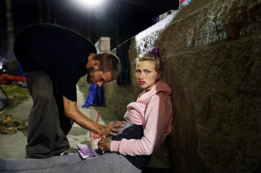 fot. Christina House, Mckenzie Trahan (22) wpatruje się w dal, gdy jej chłopak Eddie, 26, opiera rękę na jej brzuchu w pobliżu ich namiotu w Hollywood. (Opublikowano 13 lipca 2022 r.)