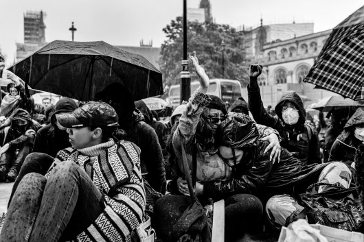 fot. Chris Mozyro, Black Lives MatterBlack Lives Matter to międzynarodowy ruch na rzecz praw człowieka, wywodzący się ze społeczności afroamerykańskiej, który prowadzi kampanie przeciwko przemocy i systemowemu rasizmowi wobec Czarnych. BLM regularnie organizuje protesty przeciwko brutalności policji i zabójstwom Czarnych przez policję, a także szerszym kwestiom, takim jak profilowanie rasowe i nierówność rasowa w systemie sądownictwa karnego Stanów Zjednoczonych. Ruch powrócił na pierwsze strony gazet i zyskał dalsze międzynarodowe zainteresowanie podczas globalnych protestów po śmierci George'a Floyda w 2020 roku w Minneapolis w Minnesocie. Floyd zmarł po aresztowaniu za rzekome wykorzystywanie fałszywych pieniędzy do kupowania papierosów. Biały policjant klęczał na jego szyi przez osiem minut i 46 sekund, co doprowadziło do jego śmierci. Wydarzenia związane z aresztowaniem, śmiercią i działaniami funkcjonariuszy doprowadziły do międzynarodowych protestów Black Lives Matter, wezwań do reformy policji i ustawodawstwa dotyczącego nierówności rasowych. Protesty wybuchły i trwają od tego czasu w wielu miastach USA, Australii, Francji, Holandii i Wielkiej Brytanii. Zdjęcia te wykonano 6 czerwca 2020 roku podczas londyńskiego protestu. Znalazłem się w centrum protestów, doświadczając całej gamy ludzkich emocji i obserwując niecodzienne zachowanie. Fakt, że protest miał miejsce podczas pandemii Covid-19, sprawia, że wydarzenie to jest jeszcze bardziej znaczące. Około godziny 23:00, po wielu godzinach stania w wściekłym tłumie, zabrano mnie na policyjne śledztwo. Oficer przesłuchał mnie i sprawdził dowód. W końcu udało mi się wyjechać, ale odradzono mi powrót do centrum miasta w ciągu 24 godzin, ponieważ groziłoby to aresztowaniem.Chris Mozyro - Chociaż obecnie mieszka w Londynie, urodził się i wychował na Litwie. Po ukończeniu polskiej szkoły podstawowej, ukończył z dyplomem Zawodowe Centrum Technologii i Biznesu w Wilnie. Praktykowanie kickboxingu we wczesnych latach pomogło mu rozwinąć dyscyplinę i odporność. Obie te cechy przydają mu się obecnie w karierze fotografa.Szybko odkrył, że fotografia jest fantastycznym sposobem na uchwycenie szerokiej gamy ludzkich emocji, i że ten temat wydaje mu się niezwykle pociągający. Wiedząc, że jego były nauczyciel jest zapalonym fotografem z dużym doświadczeniem, poprosił go o mentoring. W styczniu 2019 roku Chris wziął udział w swoich pierwszych warsztatach fotograficznych zorganizowanych przez Mariusza Śmiejeka, założyciela All Media Academy w Londynie. Wkrótce potem, uczestniczył w trzech kolejnych przedsięwzięciach tego typu, w tym w warsztatach wyjazdowych na Sycylii. Niedługo potem miał szczęście zostać zaproszony do Warszawy przez Szeroki Kadr na przegląd portfolio fotograficznego.Jego twórczość została dostrzeżona przez Szeroki Kadr i opublikowana w EYEphoto Magazine. W tym roku znalazł się także w półfinale konkursu URBAN 2020 Photo Awards.