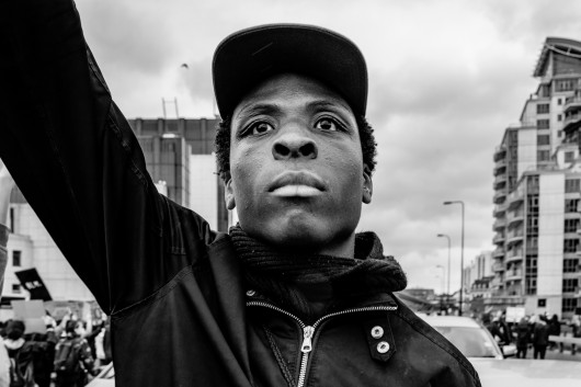 fot. Chris Mozyro, Black Lives MatterBlack Lives Matter to międzynarodowy ruch na rzecz praw człowieka, wywodzący się ze społeczności afroamerykańskiej, który prowadzi kampanie przeciwko przemocy i systemowemu rasizmowi wobec Czarnych. BLM regularnie organizuje protesty przeciwko brutalności policji i zabójstwom Czarnych przez policję, a także szerszym kwestiom, takim jak profilowanie rasowe i nierówność rasowa w systemie sądownictwa karnego Stanów Zjednoczonych. Ruch powrócił na pierwsze strony gazet i zyskał dalsze międzynarodowe zainteresowanie podczas globalnych protestów po śmierci George'a Floyda w 2020 roku w Minneapolis w Minnesocie. Floyd zmarł po aresztowaniu za rzekome wykorzystywanie fałszywych pieniędzy do kupowania papierosów. Biały policjant klęczał na jego szyi przez osiem minut i 46 sekund, co doprowadziło do jego śmierci. Wydarzenia związane z aresztowaniem, śmiercią i działaniami funkcjonariuszy doprowadziły do międzynarodowych protestów Black Lives Matter, wezwań do reformy policji i ustawodawstwa dotyczącego nierówności rasowych. Protesty wybuchły i trwają od tego czasu w wielu miastach USA, Australii, Francji, Holandii i Wielkiej Brytanii. Zdjęcia te wykonano 6 czerwca 2020 roku podczas londyńskiego protestu. Znalazłem się w centrum protestów, doświadczając całej gamy ludzkich emocji i obserwując niecodzienne zachowanie. Fakt, że protest miał miejsce podczas pandemii Covid-19, sprawia, że wydarzenie to jest jeszcze bardziej znaczące. Około godziny 23:00, po wielu godzinach stania w wściekłym tłumie, zabrano mnie na policyjne śledztwo. Oficer przesłuchał mnie i sprawdził dowód. W końcu udało mi się wyjechać, ale odradzono mi powrót do centrum miasta w ciągu 24 godzin, ponieważ groziłoby to aresztowaniem.Chris Mozyro - Chociaż obecnie mieszka w Londynie, urodził się i wychował na Litwie. Po ukończeniu polskiej szkoły podstawowej, ukończył z dyplomem Zawodowe Centrum Technologii i Biznesu w Wilnie. Praktykowanie kickboxingu we wczesnych latach pomogło mu rozwinąć dyscyplinę i odporność. Obie te cechy przydają mu się obecnie w karierze fotografa.Szybko odkrył, że fotografia jest fantastycznym sposobem na uchwycenie szerokiej gamy ludzkich emocji, i że ten temat wydaje mu się niezwykle pociągający. Wiedząc, że jego były nauczyciel jest zapalonym fotografem z dużym doświadczeniem, poprosił go o mentoring. W styczniu 2019 roku Chris wziął udział w swoich pierwszych warsztatach fotograficznych zorganizowanych przez Mariusza Śmiejeka, założyciela All Media Academy w Londynie. Wkrótce potem, uczestniczył w trzech kolejnych przedsięwzięciach tego typu, w tym w warsztatach wyjazdowych na Sycylii. Niedługo potem miał szczęście zostać zaproszony do Warszawy przez Szeroki Kadr na przegląd portfolio fotograficznego.Jego twórczość została dostrzeżona przez Szeroki Kadr i opublikowana w EYEphoto Magazine. W tym roku znalazł się także w półfinale konkursu URBAN 2020 Photo Awards.