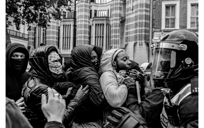 fot. Chris Mozyro, Black Lives MatterBlack Lives Matter to międzynarodowy ruch na rzecz praw człowieka, wywodzący się ze społeczności afroamerykańskiej, który prowadzi kampanie przeciwko przemocy i systemowemu rasizmowi wobec Czarnych. BLM regularnie organizuje protesty przeciwko brutalności policji i zabójstwom Czarnych przez policję, a także szerszym kwestiom, takim jak profilowanie rasowe i nierówność rasowa w systemie sądownictwa karnego Stanów Zjednoczonych. Ruch powrócił na pierwsze strony gazet i zyskał dalsze międzynarodowe zainteresowanie podczas globalnych protestów po śmierci George'a Floyda w 2020 roku w Minneapolis w Minnesocie. Floyd zmarł po aresztowaniu za rzekome wykorzystywanie fałszywych pieniędzy do kupowania papierosów. Biały policjant klęczał na jego szyi przez osiem minut i 46 sekund, co doprowadziło do jego śmierci. Wydarzenia związane z aresztowaniem, śmiercią i działaniami funkcjonariuszy doprowadziły do międzynarodowych protestów Black Lives Matter, wezwań do reformy policji i ustawodawstwa dotyczącego nierówności rasowych. Protesty wybuchły i trwają od tego czasu w wielu miastach USA, Australii, Francji, Holandii i Wielkiej Brytanii. Zdjęcia te wykonano 6 czerwca 2020 roku podczas londyńskiego protestu. Znalazłem się w centrum protestów, doświadczając całej gamy ludzkich emocji i obserwując niecodzienne zachowanie. Fakt, że protest miał miejsce podczas pandemii Covid-19, sprawia, że wydarzenie to jest jeszcze bardziej znaczące. Około godziny 23:00, po wielu godzinach stania w wściekłym tłumie, zabrano mnie na policyjne śledztwo. Oficer przesłuchał mnie i sprawdził dowód. W końcu udało mi się wyjechać, ale odradzono mi powrót do centrum miasta w ciągu 24 godzin, ponieważ groziłoby to aresztowaniem.Chris Mozyro - Chociaż obecnie mieszka w Londynie, urodził się i wychował na Litwie. Po ukończeniu polskiej szkoły podstawowej, ukończył z dyplomem Zawodowe Centrum Technologii i Biznesu w Wilnie. Praktykowanie kickboxingu we wczesnych latach pomogło mu rozwinąć dyscyplinę i odporność. Obie te cechy przydają mu się obecnie w karierze fotografa.Szybko odkrył, że fotografia jest fantastycznym sposobem na uchwycenie szerokiej gamy ludzkich emocji, i że ten temat wydaje mu się niezwykle pociągający. Wiedząc, że jego były nauczyciel jest zapalonym fotografem z dużym doświadczeniem, poprosił go o mentoring. W styczniu 2019 roku Chris wziął udział w swoich pierwszych warsztatach fotograficznych zorganizowanych przez Mariusza Śmiejeka, założyciela All Media Academy w Londynie. Wkrótce potem, uczestniczył w trzech kolejnych przedsięwzięciach tego typu, w tym w warsztatach wyjazdowych na Sycylii. Niedługo potem miał szczęście zostać zaproszony do Warszawy przez Szeroki Kadr na przegląd portfolio fotograficznego.Jego twórczość została dostrzeżona przez Szeroki Kadr i opublikowana w EYEphoto Magazine. W tym roku znalazł się także w półfinale konkursu URBAN 2020 Photo Awards.