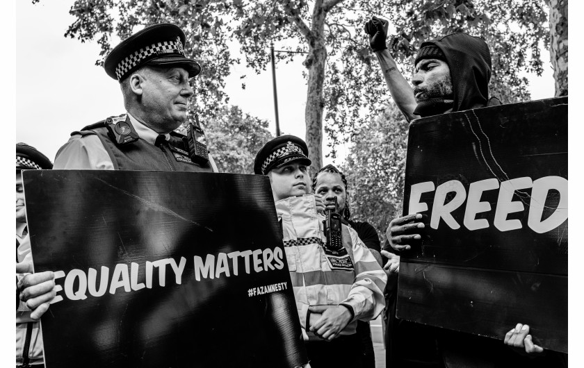 fot. Chris Mozyro, Black Lives MatterBlack Lives Matter to międzynarodowy ruch na rzecz praw człowieka, wywodzący się ze społeczności afroamerykańskiej, który prowadzi kampanie przeciwko przemocy i systemowemu rasizmowi wobec Czarnych. BLM regularnie organizuje protesty przeciwko brutalności policji i zabójstwom Czarnych przez policję, a także szerszym kwestiom, takim jak profilowanie rasowe i nierówność rasowa w systemie sądownictwa karnego Stanów Zjednoczonych. Ruch powrócił na pierwsze strony gazet i zyskał dalsze międzynarodowe zainteresowanie podczas globalnych protestów po śmierci George'a Floyda w 2020 roku w Minneapolis w Minnesocie. Floyd zmarł po aresztowaniu za rzekome wykorzystywanie fałszywych pieniędzy do kupowania papierosów. Biały policjant klęczał na jego szyi przez osiem minut i 46 sekund, co doprowadziło do jego śmierci. Wydarzenia związane z aresztowaniem, śmiercią i działaniami funkcjonariuszy doprowadziły do międzynarodowych protestów Black Lives Matter, wezwań do reformy policji i ustawodawstwa dotyczącego nierówności rasowych. Protesty wybuchły i trwają od tego czasu w wielu miastach USA, Australii, Francji, Holandii i Wielkiej Brytanii. Zdjęcia te wykonano 6 czerwca 2020 roku podczas londyńskiego protestu. Znalazłem się w centrum protestów, doświadczając całej gamy ludzkich emocji i obserwując niecodzienne zachowanie. Fakt, że protest miał miejsce podczas pandemii Covid-19, sprawia, że wydarzenie to jest jeszcze bardziej znaczące. Około godziny 23:00, po wielu godzinach stania w wściekłym tłumie, zabrano mnie na policyjne śledztwo. Oficer przesłuchał mnie i sprawdził dowód. W końcu udało mi się wyjechać, ale odradzono mi powrót do centrum miasta w ciągu 24 godzin, ponieważ groziłoby to aresztowaniem.Chris Mozyro - Chociaż obecnie mieszka w Londynie, urodził się i wychował na Litwie. Po ukończeniu polskiej szkoły podstawowej, ukończył z dyplomem Zawodowe Centrum Technologii i Biznesu w Wilnie. Praktykowanie kickboxingu we wczesnych latach pomogło mu rozwinąć dyscyplinę i odporność. Obie te cechy przydają mu się obecnie w karierze fotografa.Szybko odkrył, że fotografia jest fantastycznym sposobem na uchwycenie szerokiej gamy ludzkich emocji, i że ten temat wydaje mu się niezwykle pociągający. Wiedząc, że jego były nauczyciel jest zapalonym fotografem z dużym doświadczeniem, poprosił go o mentoring. W styczniu 2019 roku Chris wziął udział w swoich pierwszych warsztatach fotograficznych zorganizowanych przez Mariusza Śmiejeka, założyciela All Media Academy w Londynie. Wkrótce potem, uczestniczył w trzech kolejnych przedsięwzięciach tego typu, w tym w warsztatach wyjazdowych na Sycylii. Niedługo potem miał szczęście zostać zaproszony do Warszawy przez Szeroki Kadr na przegląd portfolio fotograficznego.Jego twórczość została dostrzeżona przez Szeroki Kadr i opublikowana w EYEphoto Magazine. W tym roku znalazł się także w półfinale konkursu URBAN 2020 Photo Awards.