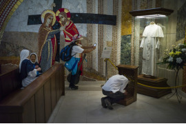 fot. Wojciech Grzędziński, dla Aleteia.pl. 3. miejsce w kategorii kultura i Rozrywka.

Kraków. Światowe Dni Młodzieży to spotkania młodych katolików z papieżem zapoczątkowane w 1986 roku przez Jana Pawła II w Rzymie. Wierni z całego świata spotykają się co dwa lata w różnych miejscach, by wspólnie się modlić, poznawać i bawić. W 2016 roku w Krakowie na spotkanie z papieżem Franciszkiem przybyły prawie 2 mln pielgrzymów. Na zdjęciu: sanktuarium w Krakowie-Łagiewnikach; pielgrzym modli się przed zakrwawioną sutanną Jana Pawła II, inni fotografują i rozmawiają. Zdjęcie pochodzi z fotoreportażu. 24 lipca 2016.