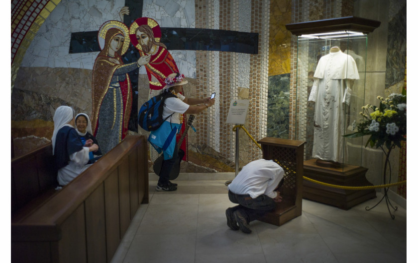 fot. Wojciech Grzędziński, dla Aleteia.pl. 3. miejsce w kategorii kultura i Rozrywka.

Kraków. Światowe Dni Młodzieży to spotkania młodych katolików z papieżem zapoczątkowane w 1986 roku przez Jana Pawła II w Rzymie. Wierni z całego świata spotykają się co dwa lata w różnych miejscach, by wspólnie się modlić, poznawać i bawić. W 2016 roku w Krakowie na spotkanie z papieżem Franciszkiem przybyły prawie 2 mln pielgrzymów. Na zdjęciu: sanktuarium w Krakowie-Łagiewnikach; pielgrzym modli się przed zakrwawioną sutanną Jana Pawła II, inni fotografują i rozmawiają. Zdjęcie pochodzi z fotoreportażu. 24 lipca 2016.