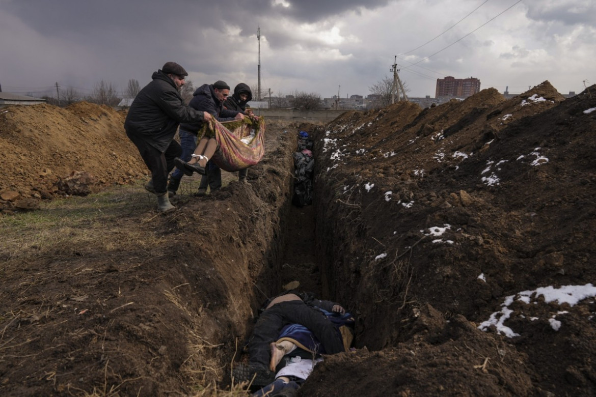 fot. Evgeniy Maloletka, Ciała składane do masowego grobu na obrzeżach Mariupola, Ukraina, 9 marca 2022.