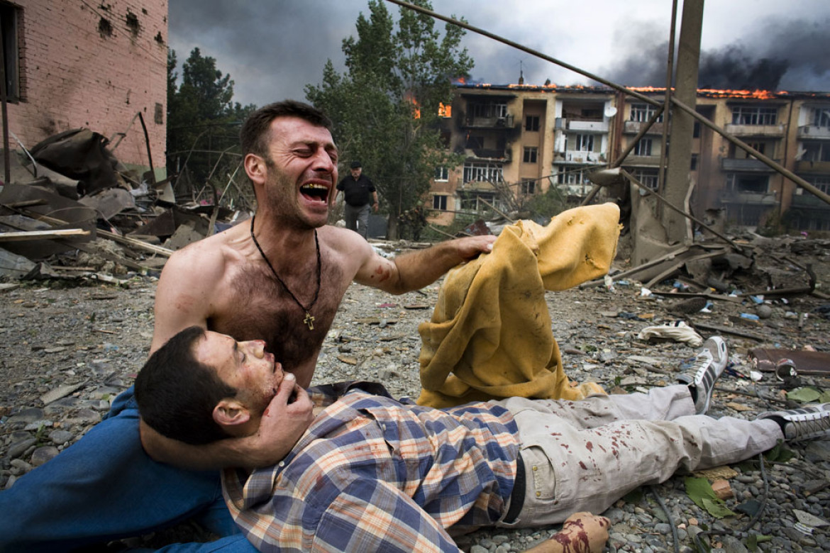 WOJCIECH GRZĘDZIŃSKI, NAPO IMAGES/DZIENNIK. Mężczyzna rozpacza nad zwłokami swojego brata zabitego podczas nalotu rosyjskiego lotnictwa na trzy cywilne budynki w mieście Gori. Gori (Gruzja), 9 sierpnia 2008 r.