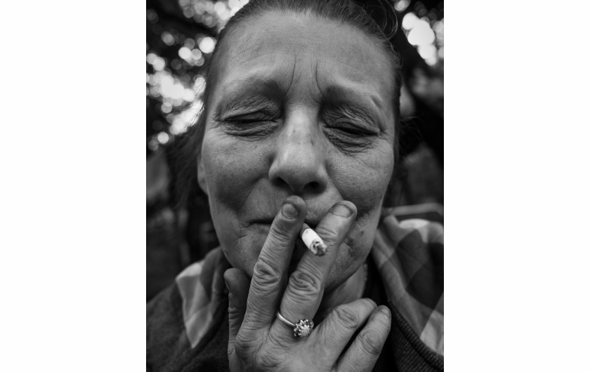 Fot. Maciej Grzybowski, 1. miejsce w kat. Documentary Project / Grand Press Photo 2024Ela, Darek i Mirek są w bezdomności od wielu lat. Mieszkają w lesie nad rzeką, na obrzeżach miasta. Opiekują się dwoma psami Florą i Jogim. Ela przez kilkanaście lat pracowała w zakładach farmaceutycznych. Jest wdową, jej syn mieszka za granicą. Obecnie bezrobotna. Darek, partner Eli, podejmuje się prac dorywczych na budowach i w firmach sprzątających miasto. Sam zbudował wszystkie domki. Mirek pochodzi z Pomorza, jest wolnym duchem. Często wychodzi w nocy zbierać złom, który potem sprzedaje.
W Polsce około 30 tysięcy osób znajduje się w kryzysie bezdomności, z czego ponad 80 proc. stanowią mężczyźni.
