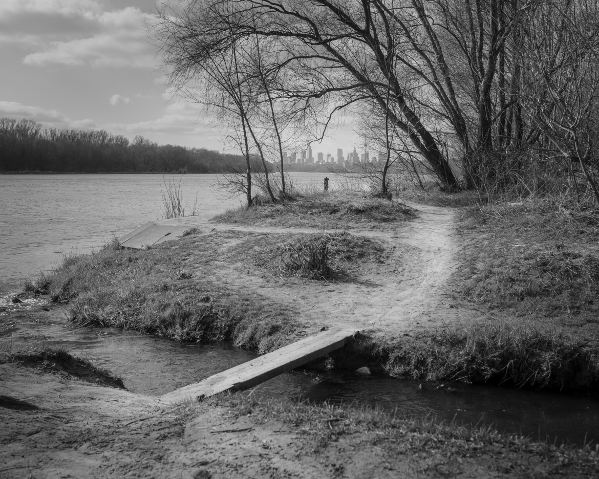 Fot. Maciej Grzybowski, 1. miejsce w kat. Documentary Project / Grand Press Photo 2024<br></br><br></br>Ela, Darek i Mirek są w bezdomności od wielu lat. Mieszkają w lesie nad rzeką, na obrzeżach miasta. Opiekują się dwoma psami Florą i Jogim. Ela przez kilkanaście lat pracowała w zakładach farmaceutycznych. Jest wdową, jej syn mieszka za granicą. Obecnie bezrobotna. Darek, partner Eli, podejmuje się prac dorywczych na budowach i w firmach sprzątających miasto. Sam zbudował wszystkie domki. Mirek pochodzi z Pomorza, jest wolnym duchem. Często wychodzi w nocy zbierać złom, który potem sprzedaje.
W Polsce około 30 tysięcy osób znajduje się w kryzysie bezdomności, z czego ponad 80 proc. stanowią mężczyźni.