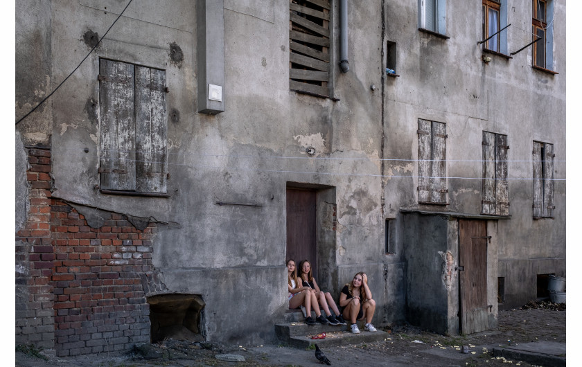 Fot. Amadeusz Świerk, 2. miejsce w kat. Documentary Project / Grand Press Photo 2024 Złodzieje o złotych sercach. Rodziny próbujące żyć normalnie wbrew przeciwnościom losu. Byli więźniowie z duszami pełnymi artyzmu i muzyki. Młodzież szukająca własnej drogi pomimo trudnego startu. Witamy w Dzielnicy Cudów. Zakaczawie to dzielnica Legnicy, stutysięcznego miasta położonego na Dolnym Śląsku, które po II wojnie światowej miało wątpliwą przyjemność stacjonowania około 60 tys. żołnierzy radzieckich.
W trudnych czasach, które zakończyły się dopiero w 1993 roku, Zakaczawie stało się nieformalnym centrum życia społecznego Polaków. Pomimo cienia radzieckiego garnizonu, wśród polskich rodzin i silnej społeczności romskiej przesiedlonej do dzielnicy przez komunistów kwitły małe przedsiębiorstwa, kawiarnie, bary i miejsca kultury.
Niemal w każdym mieście jest podobne miejsce, którego mieszkańcy cierpią z powodu marginalizacji społecznej i ekonomicznej. Projekt ten ma na celu pokazanie, że wśród biedy i zniszczonych trudnych dzielnic są ludzie – rodziny, przyjaciele, kochankowie – starający się żyć najlepiej, jak potrafią.