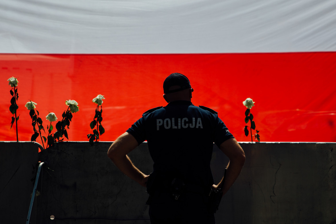 Krystian Maj - Warszawa. 18.07.2017 Przed barykadami odgradzającymi Sejm protestujący ustawili kilkumetrowa flagę Polski, a w ogrodzenie powkładali białe róże – symbol oporu przeciwko władzy.
