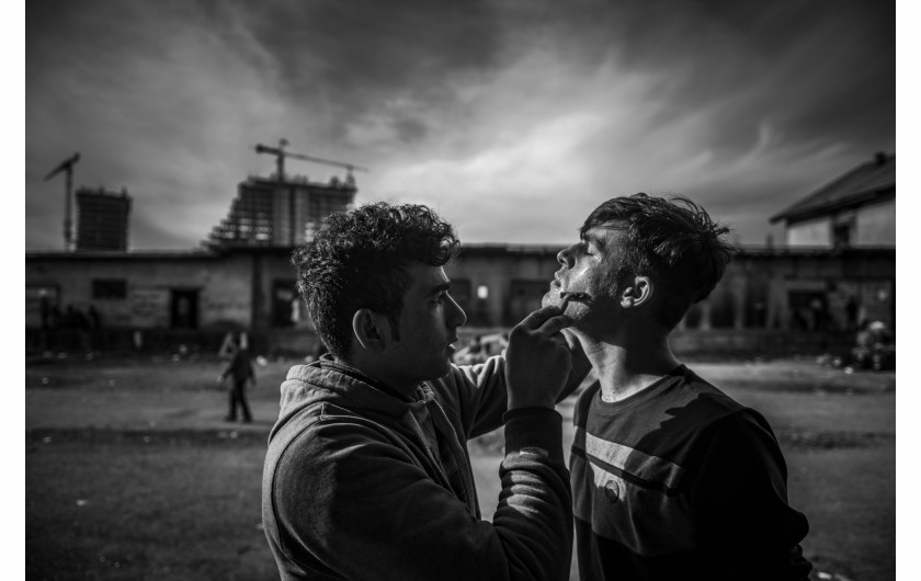 Fotoreportaż - Szymon Barylski (wybrane kadry) - Uchodźca goli się na terenie opuszczonych magazynów, które jest ich tymczasowym schronieniem. Belgrad, Serbia 2 Marca 2017.