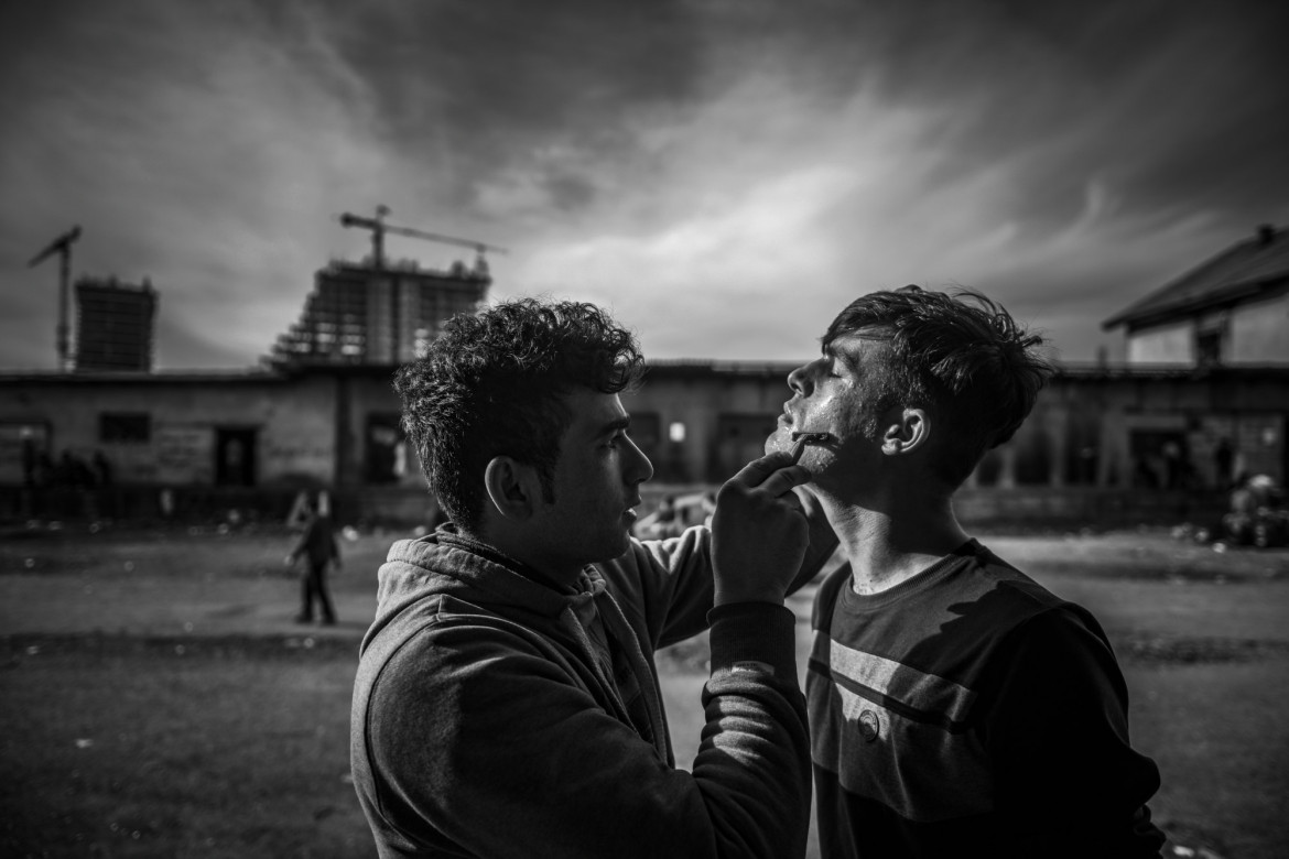 Fotoreportaż - Szymon Barylski (wybrane kadry) - Uchodźca goli się na terenie opuszczonych magazynów, które jest ich tymczasowym schronieniem. Belgrad, Serbia 2 Marca 2017.