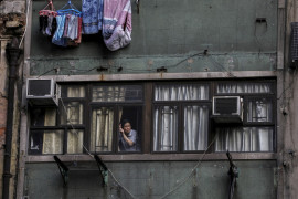 fot. Ammar Wad. Kobieta obserwuje marsz tysięcy protestujących z okna swojego mieszkania. Hong Kong, Chiny, 20 października 2019 / Pulitzer Prize for Breaking News Photography 2020
