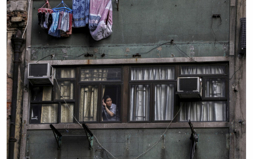 fot. Ammar Wad. Kobieta obserwuje marsz tysięcy protestujących z okna swojego mieszkania. Hong Kong, Chiny, 20 października 2019 / Pulitzer Prize for Breaking News Photography 2020