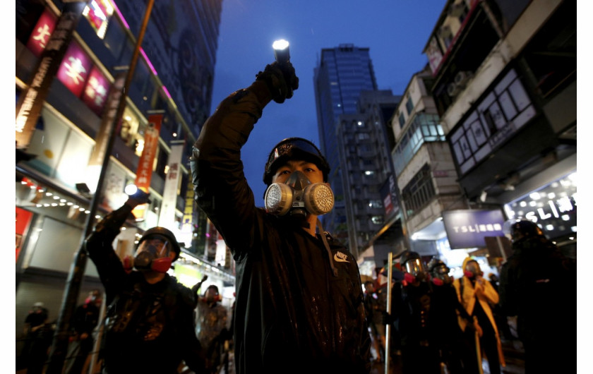 fot. Willy Kurniawan. Protestujący przeciw ustawie o ekstradycji kierują swoje latarki w stronę kordonów policji tłumiących zamieszki. Hong Kong, Chiny, 25 sierpnia 2019 / Pulitzer Prize for Breaking News Photography 2020