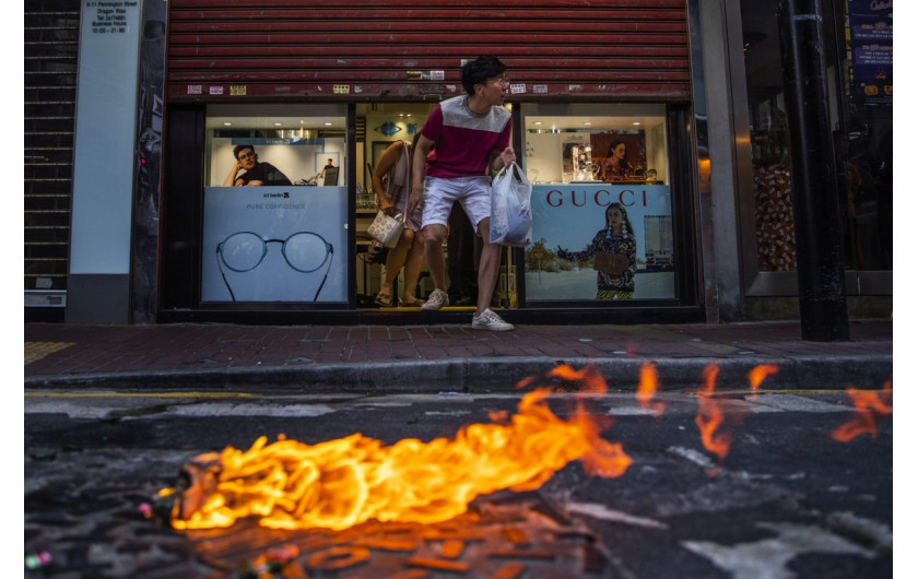 fot. Tyrone Siu. Klienci ostrożnie wychodzą ze sklepu optycznego podczas starcia protestujących z policją. Hong Kong, Chiny, 2 listopada 2019 / Pulitzer Prize for Breaking News Photography 2020