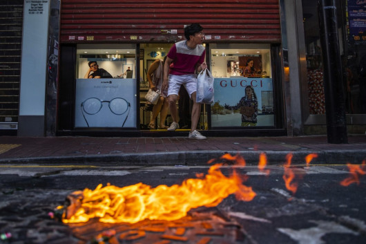 fot. Tyrone Siu. Klienci ostrożnie wychodzą ze sklepu optycznego podczas starcia protestujących z policją. Hong Kong, Chiny, 2 listopada 2019 / Pulitzer Prize for Breaking News Photography 2020