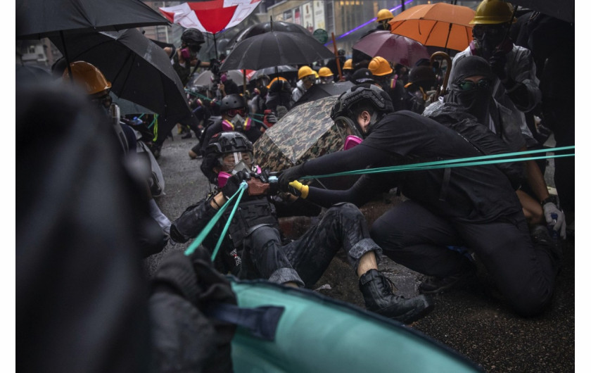 fot. Tyrone Siu. Protestujący, podczas demonstracji tworzą prowizoryczne proce, które wykorzystując do miotania cegieł w stronę policji. Hong Kong, Chiny, 25 sierpnia 2019 / Pulitzer Prize for Breaking News Photography 2020