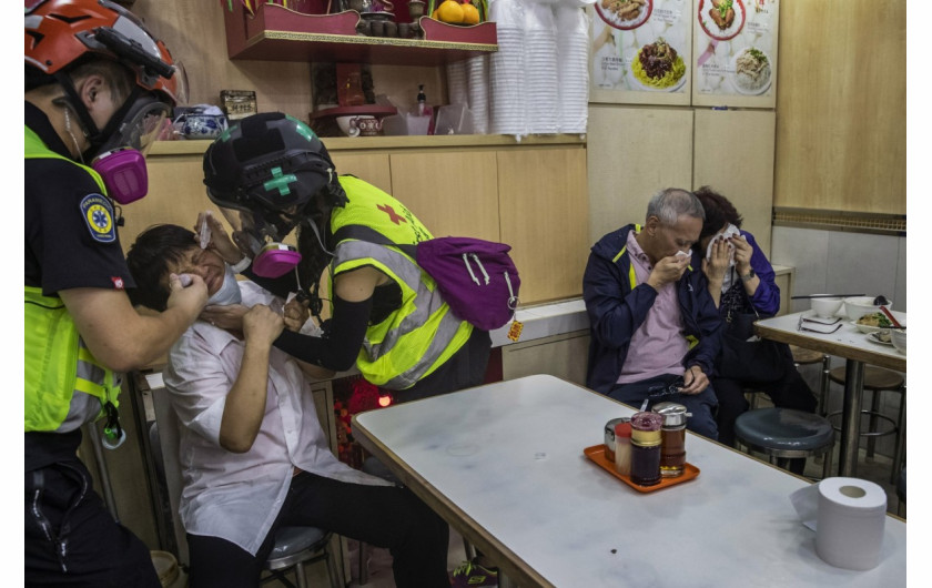 fot. Tyrone Siu. Pracownik restauracji otrzymuje pomoc od wolontariuszy po tym, jak policja użyła gazu łzawiącego do tłumienia protestów. Hong Kong, Chiny, 2 listopada 2019 / Pulitzer Prize for Breaking News Photography 2020