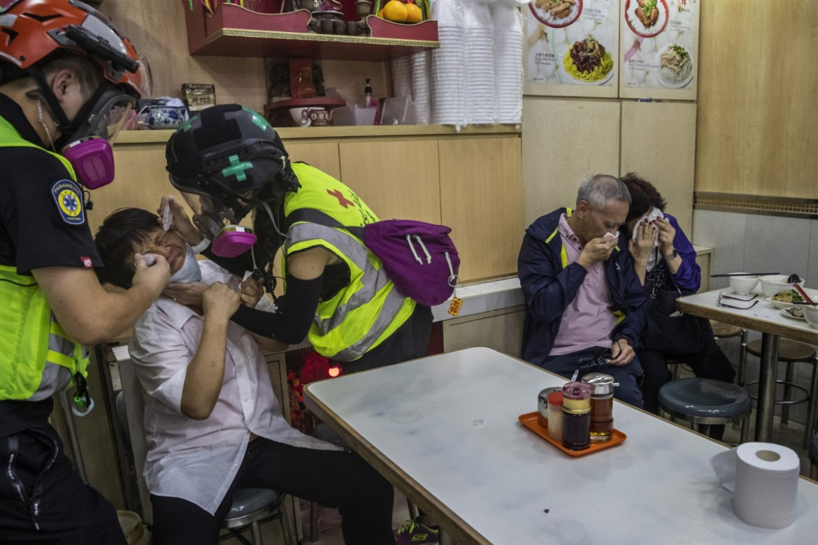 fot. Tyrone Siu. Pracownik restauracji otrzymuje pomoc od wolontariuszy po tym, jak policja użyła gazu łzawiącego do tłumienia protestów. Hong Kong, Chiny, 2 listopada 2019 / Pulitzer Prize for Breaking News Photography 2020