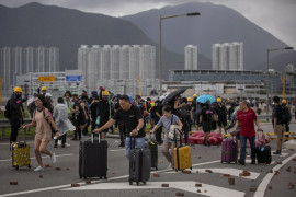 fot. Anushree Fadnavis. Pasażerowie omijają rzucone cegły po tym jak protestujący zablokowali drogi prowadzące do międzynarodowego lotniska w Hong Kongu. 1 września 2019 / Pulitzer Prize for Breaking News Photography 2020