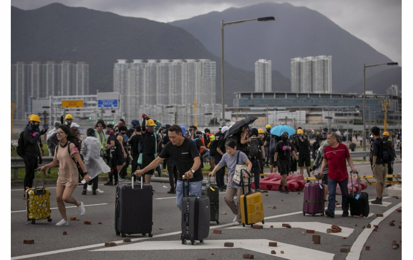 fot. Anushree Fadnavis. Pasażerowie omijają rzucone cegły po tym jak protestujący zablokowali drogi prowadzące do międzynarodowego lotniska w Hong Kongu. 1 września 2019 / Pulitzer Prize for Breaking News Photography 2020