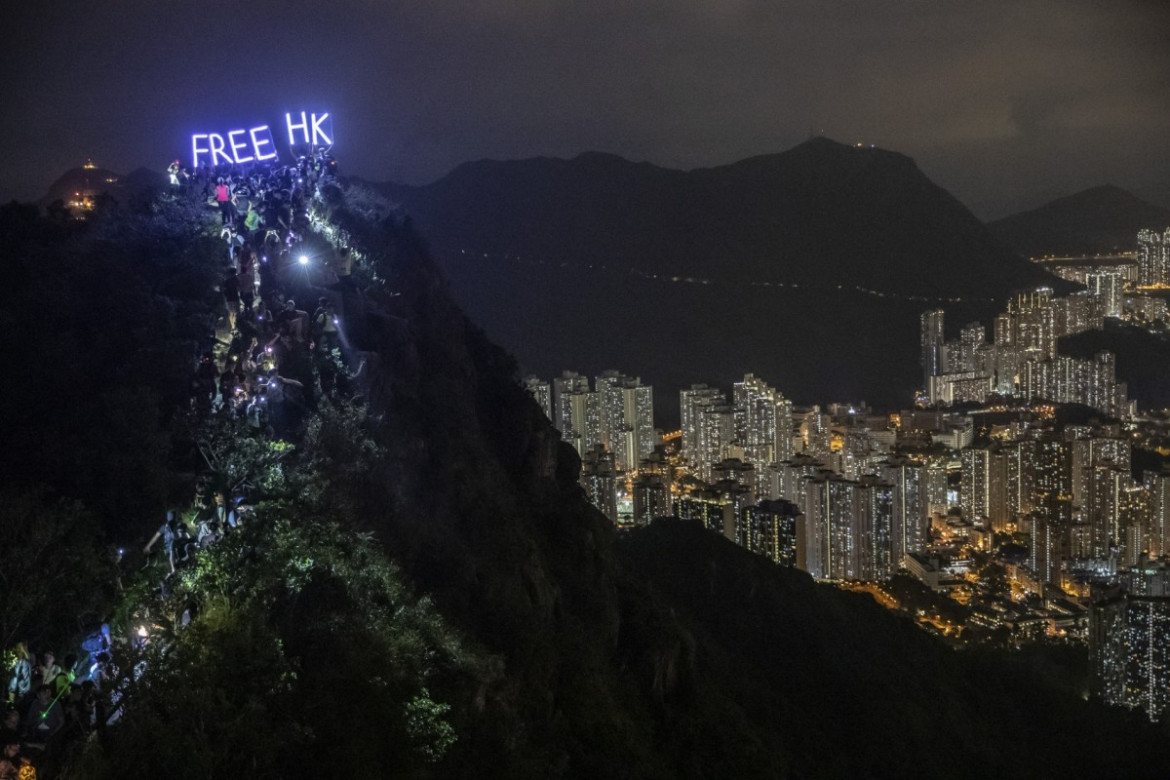 fot. Athit Perawongmetha. Setki protestujących wspina się na szczyt skały Lion Rock, na której umieszczono świecący napis nawołujący do uwolnienia Hong Kongu spod władzy Chin. 13 września 2019 / Pulitzer Prize for Breaking News Photography 2020