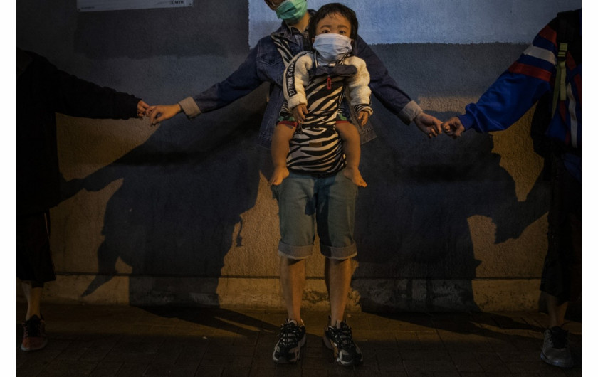 fot. Leah Millis. Dziecko w nosidełku sfotografowane podczas tworzenia ludzkiego łańcucha na rzecz solidarności z protestującymi w Kowloon Bay. Hong Kong, Chiny, 30 listopada 2019 /  Pulitzer Prize for Breaking News Photography 2020