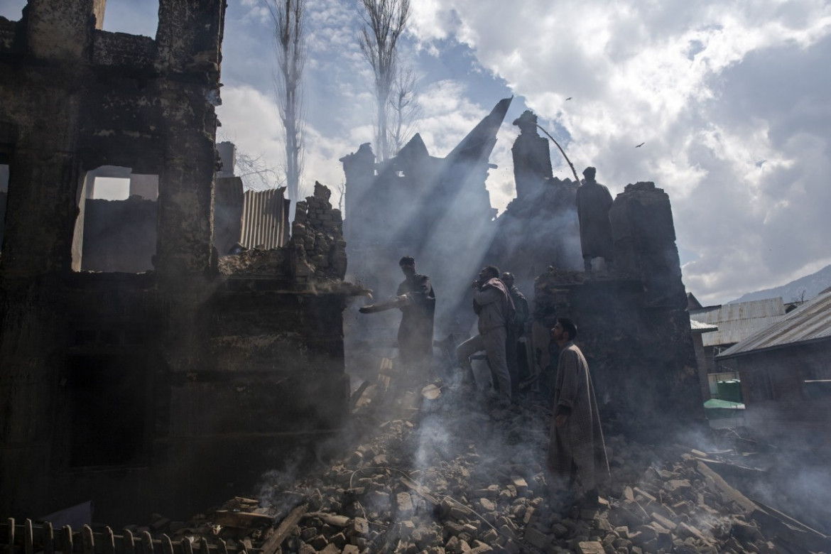 fot. Dar Yasin. Mężczyźni wyburzają część domu zniszczonego podczas strzelaniny w wiosce Tral, w indyjskiej części Kaszmiru. 4 marca 2019 / The Pulitzer Prize 2020 for Feature Photography