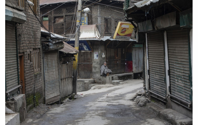 fot. Dar Yasin. Starszy mężczyzna siedzi przed zamkniętym sklepem podczas strajków w Srinagar. 17 lutego 2019 / The Pulitzer Prize 2020 for Feature Photography