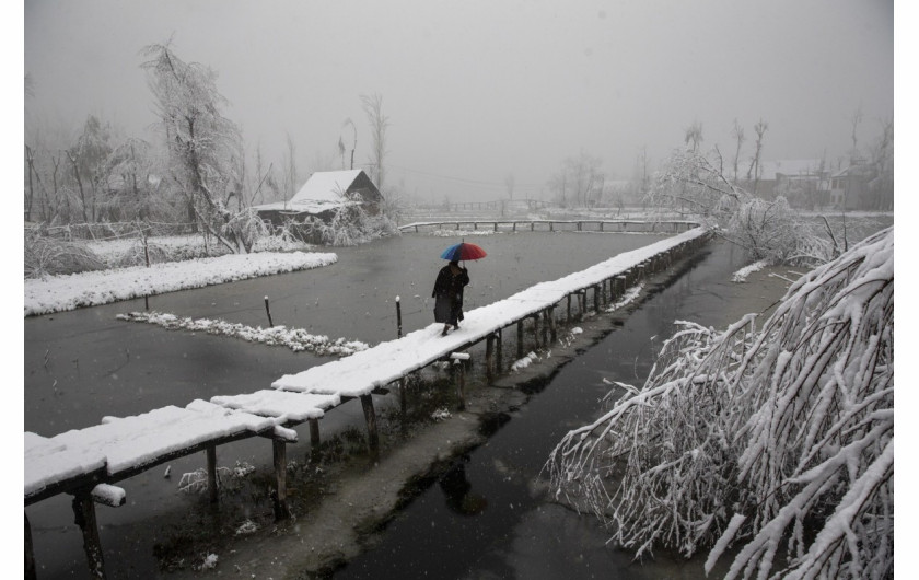 fot. Dar Yasin. Mężczyzna spaceruje po pieszym moście na jeziorze Dal w Srinagar. 13 grudnia 2019 / The Pulitzer Prize 2020 for Feature Photography