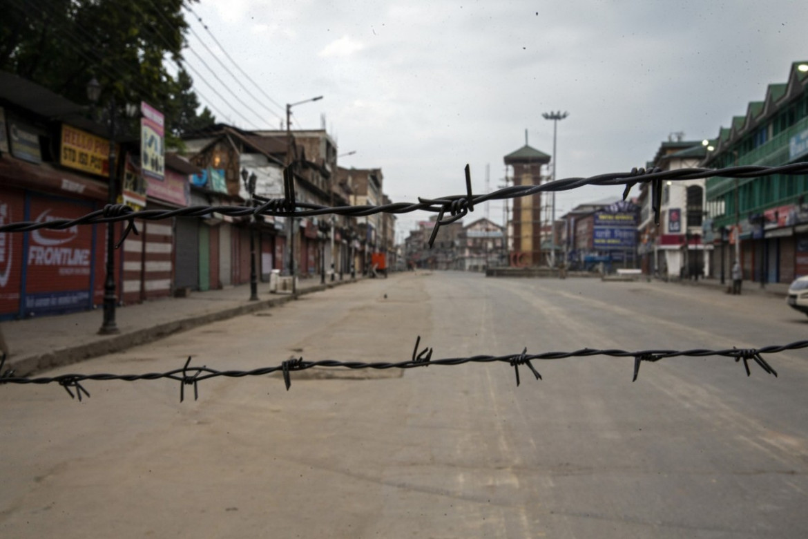 fot. Dar Yasin. Opustoszała ulica podczas godziny policyjnej, widziana przez drut kolczasty na jednej z ulicznych blokad. Sringar, 6 sierpnia 2019 / The Pulitzer Prize 2020 for Feature Photography