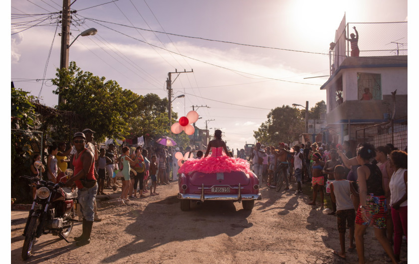 fot. Diana Markosia, Magnum Photos, The Cubanitas, 1. miejsce w kategorii Contemporary Issues.

15 urodziny w kulturze latynoskiej oznaczają wejście kobiety w dorosłość. Rodziny urządzają z tej okazji kosztowne przyjęcia, a solenizantki ubierane i traktowane są jak księżniczki. Na Kubie tradycja ta wyewoluowała w przedstawienie w skład którego wchodzą sesje zdjęciowe i wideo. Na zdjęciu 15-letnia Pura podróżująca przez swoją dzielnicę w kabriolecie z lat 50., otoczona przez mieszkańców, którzy zebrali się, by świętować jej urodziny.