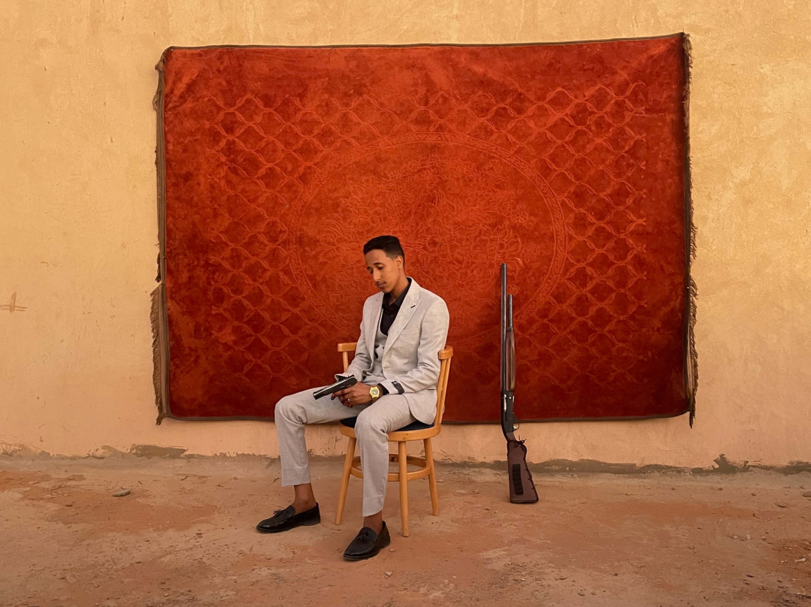 Fot. Mosab Abushama, "Life Won't Stop", nagroda w kat. regionalnej Africa / World Press Photo 2025<br></br><br></br>Pan młody pozuje do portretu na swoim ślubie. W Sudanie tradycją jest świętowanie ślubu uroczystą strzelaniną. Omdurman, Sudan, 12 stycznia 2024 r.<br></br><br></br>W styczniu 2024 r. fotograf został poproszony przez przyjaciela o udokumentowanie jego ślubu w Omdurmanie, mieście stale będącym celem nalotów. „Pomimo starć i przypadkowych ostrzałów w mieście, ślub był prostym, ale radosnym wydarzeniem. Wojna w Sudanie, która rozpoczęła się w kwietniu 2023 r., przyniosła okropności i przesiedlenia, zmuszając mnie do opuszczenia domu z dzieciństwa i przeniesienia się do innej części miasta. Był to czas, którego nikt z nas nie spodziewał się przeżyć. Jednak ten ślub był przypomnieniem radości codziennego życia, która wciąż jest możliwa pośród tragedii i rozpaczy” - wyjaśnia Mosab. Zdjęcie zostało zrobione aparatem telefonu komórkowego.