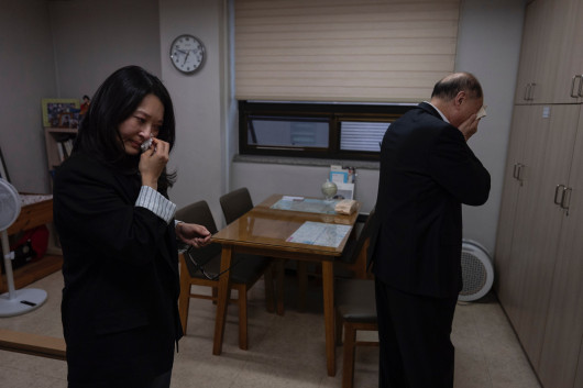 Fot. Jae C. Hong, Associated Press, Korea Adoption Fraud, nagroda w kat. regionalnej Asia-Pacific and Oceania / World Press Photo 2025Nicole Motta (z lewej) i jej biologiczny ojciec Jang Dae-chang ocierają łzy po emocjonalnym spotkaniu, około 40 lat po ich rozstaniu. Seul, 31 maja 2024 r.

Dokumenty Nicole mówią, że została adoptowana z koreańskiego sierocińca w 1985 roku, po tym jak trafiła pod opiekę sąsiadów. Dae-chang mówi, że jego rodzina została rozłączona po upadku jego biznesu. Kiedy próbował odnaleźć Nicole, dowiedział się, że krewny ją oddał. Około 200 000 koreańskich dzieci zostało wysłanych na adopcję do USA od lat pięćdziesiątych XX wieku. Dochodzenie Associated Press ujawniło dowody na fałszowanie dokumentacji w wielu z tych przypadków. Dzieci takie jak Nicole dorastały w poszukiwaniu swoich korzeni, ale odkryły, że ich historia życia nie jest taka, jak im się wydawało