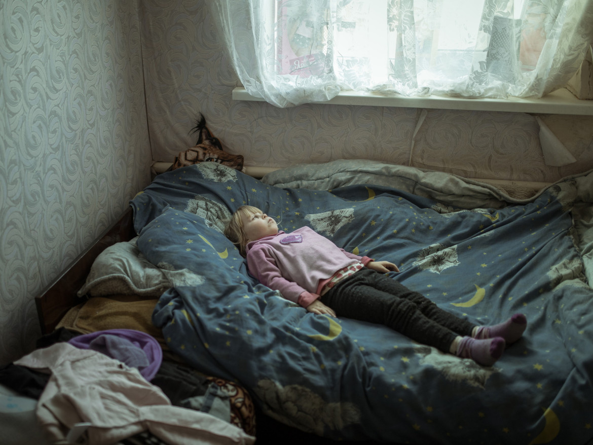 Fot. Florian Bachmeier, "Beyond the Trenches", nagroda w kat. regionalnej Europe / World Press Photo 2025<br></br><br></br>Anhelina (6), która doznała traumy i cierpi na ataki paniki po ucieczce ze swojej wioski, leży w łóżku w nowym domu. Borszcziwka, Ukraina, 7 marca 2024 r. <br></br><br></br>
Trwający konflikt w Ukrainie zmusił rodzinę Anheliny do szukania schronienia. Anhelina mieszka teraz ze swoją babcią Larisą w Borszcziwce, 95 kilometrów od Kupiańska, podczas gdy jej matka mieszka i pracuje w Charkowie - około godziny drogi stamtąd. Fotograf chciał rzucić światło na dzieci, które dorastały w otoczeniu przemocy. Ich niewinność została złamana, ale ich duch przetrwał, gdy przystosowywały się do nowego życia.