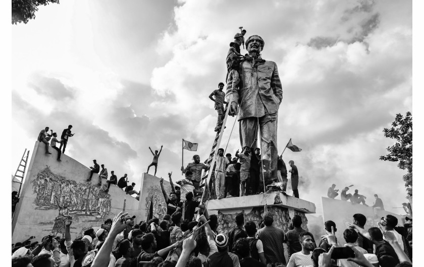 Fot. Suvra Kanti Das, for The Daily Prothom Alo, The Canvas of Power, nagroda w kat. regionalnej West , Central & South Asia / World Press Photo 2025Ludzie dewastują pomnik byłego prezydenta Bangladeszu, Sheikha Mujibura Rahmana, ojca premier Sheikh Hasiny, która podała się do dymisji po tygodniach niepokojów. Dhaka, Bangladesz, 5 sierpnia 2024 r.
W lipcu 2024 r. protest studentów przeciwko restrykcyjnemu rządowemu systemowi kwot zatrudnienia przerodził się w masowe powstanie przeciwko rządowi oskarżonemu o bezprawne zatrzymania, zaginięcia i powszechne tłumienie sprzeciwu. Niepokoje miały miejsce na tle walki o uczciwe wybory i ustawy o cyberbezpieczeństwie, która miała ograniczać wolność słowa.

Demonstracje, choć początkowo pokojowe, stały się gwałtowne po tym, jak władze i prorządowe oddziały paramilitarne rozprawiły się z protestującymi, zabijając co najmniej 1400 osób. Do sierpnia reżim upadł. Premier Sheikh Hasina podała się do dymisji i udała się na wygnanie, a szef armii generał Waker-Uz-Zaman ogłosił utworzenie rządu tymczasowego.