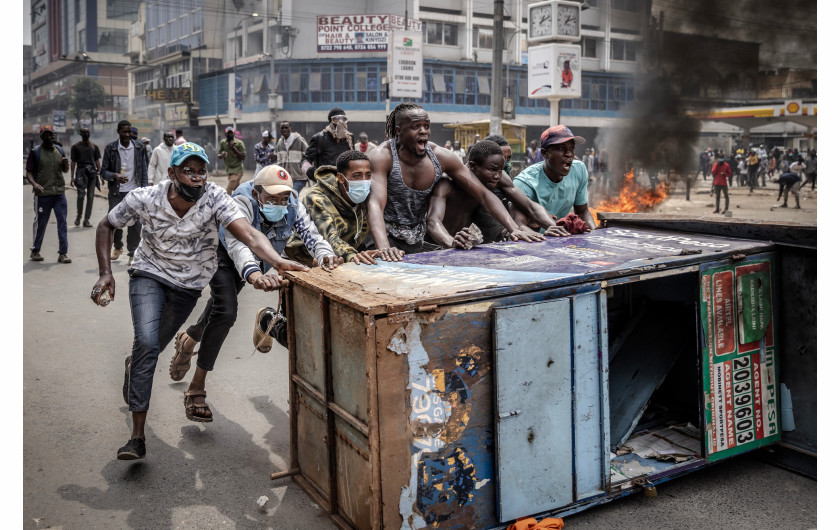 Z cyklu: Kenya's Youth Uprising
fot. Luis Tato / Agence France-Presse / World Press Photo 2025



W 2024 roku kenijski Skarb Państwa zaproponował wprowadzenie dodatkowych podatków na codzienne produkty, aby zwiększyć dochody państwa i zmniejszyć wysokie zadłużenie kraju. Propozycja ta wywołała falę protestów, zainicjowanych przez młodych Kenijczyków, którzy organizowali się za pośrednictwem mediów społecznościowych. 25 czerwca demonstranci wtargnęli do Parlamentu i starli się z policją; wielu zginęło lub zostało uprowadzonych, a setki odniosły obrażenia. Choć prezydent William Ruto wycofał kontrowersyjną ustawę, protesty trwają nadal w 2025 roku, podsycane gniewem wobec trudnej sytuacji gospodarczej, korupcji, brutalności policji i brakiem zaufania do klasy politycznej. W całym kraju młodzi ludzie stali się siłą napędową, domagając się odpowiedzialności i głębokich reform systemowych.