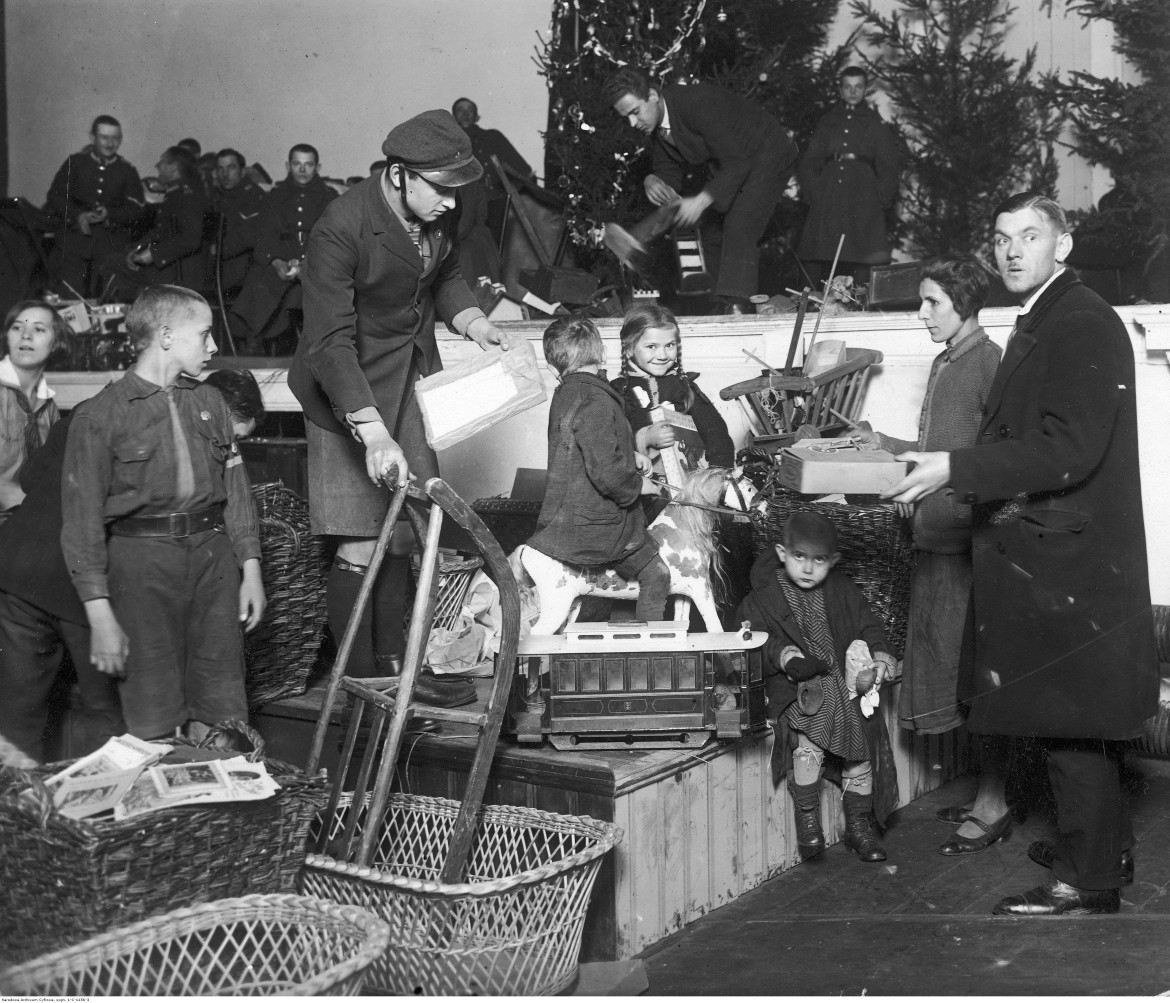 Rozdawanie zabawek dzieciom biorącym udział w wigilii. W głębi widoczna orkiestra wojskowa 31 p.p., 1926 / Narodowe Archiwum Cyfrowe