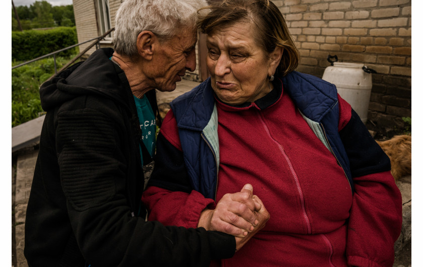 Natasza (61 l.) rozmawia z przyjacielem, siedząc przed bunkrem w Kutuziwce, jednej z wiosek wyzwolonych przez armię ukraińską spod rosyjskiej okupacji. Natasza cały czas okupacji spędziła na wsi. Jej dom został zniszczony podczas ostrzału 3 maja. Jest cukrzykiem i najbardziej martwi ją brak zapasów leków. Ukraina, 22 maja 2022
fot. Wojciech Grzędziński