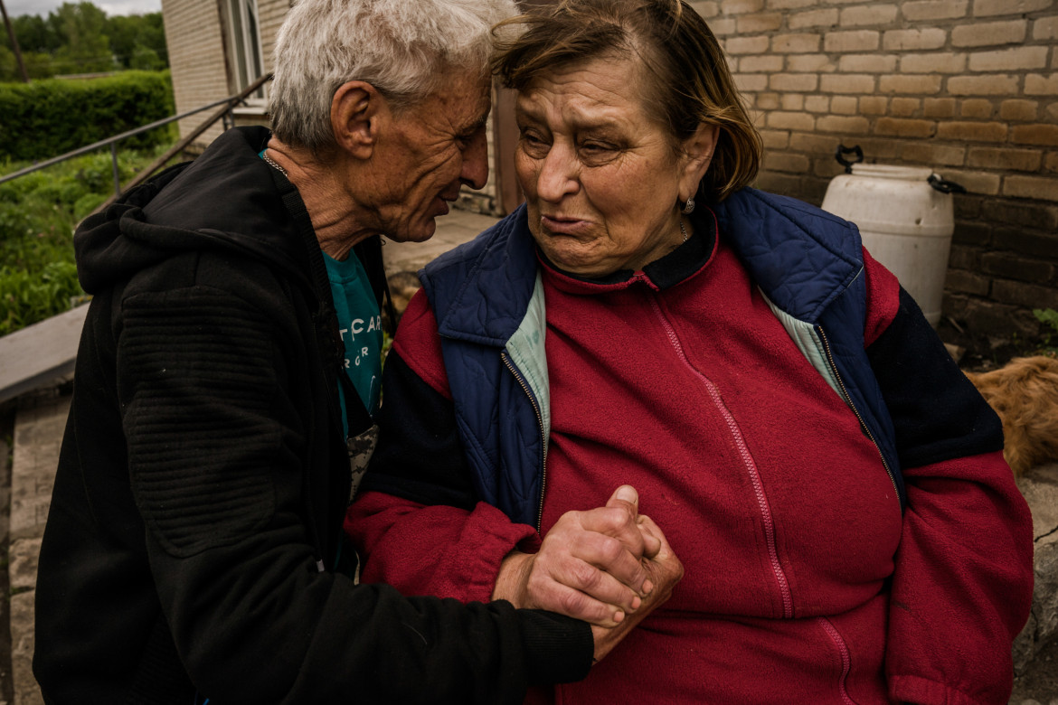 Natasza (61 l.) rozmawia z przyjacielem, siedząc przed bunkrem w Kutuziwce, jednej z wiosek wyzwolonych przez armię ukraińską spod rosyjskiej okupacji. Natasza cały czas okupacji spędziła na wsi. Jej dom został zniszczony podczas ostrzału 3 maja. Jest cukrzykiem i najbardziej martwi ją brak zapasów leków. Ukraina, 22 maja 2022
fot. Wojciech Grzędziński