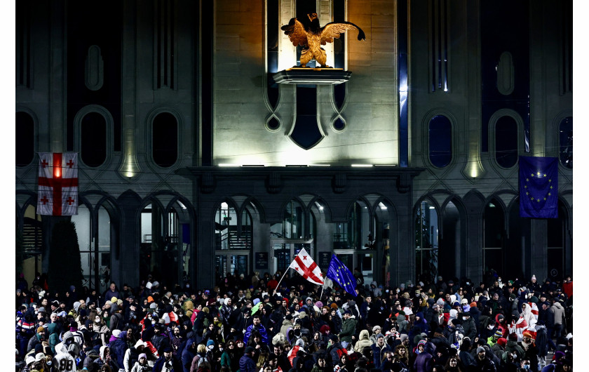 Z cyklu: Protests in Georgia
fot. Mikhail Tereshchenko / TASS Agency / World Press Photo 2025



W listopadzie 2024 roku obywatele Gruzji masowo wyszli na ulice po ogłoszeniu przez premiera Irakliego Kobakhidze czteroletniego zawieszenia rozmów akcesyjnych z Unią Europejską. Decyzja ta zapadła po tym, jak Parlament Europejski zakwestionował uczciwość ostatnich wyborów w Gruzji, wskazując na możliwe fałszerstwa. W stolicy kraju, Tbilisi, tysiące osób demonstrowało, a przed budynkiem parlamentu doszło do starć protestujących z policją. Choć pod koniec grudnia władze brutalnie rozprawiły się z przejawami sprzeciwu, uchwalając prawo penalizujące nawet symboliczne formy protestu – takie jak publiczne rozwieszanie naklejek – demonstracje nie ustały.
