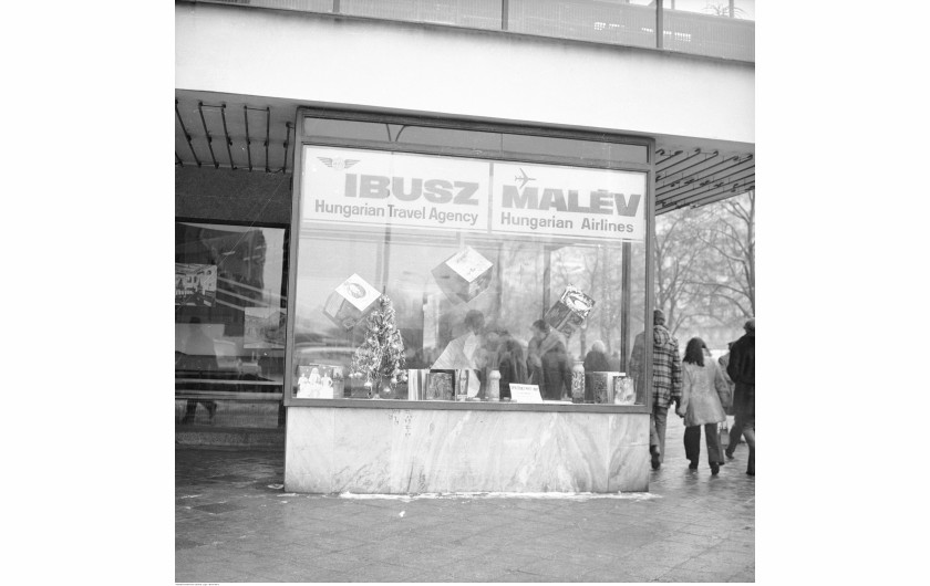 Gablota reklamowa z choinką i reklamami płyt winylowych. Widoczny szyld IBUSZ - Hungarian Travel Agency i MALEW - Hungarian Airlines, Warszawa, 1976-82 / Narodowe Archiwum Cyfrowe