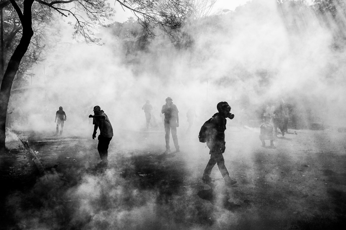 fot. Alejandro Cegarra, "State of Decay", 3. miejsce w kategorii Long Term Projects.
Pod wodzą Hugo Chaveza, który rządził krajem od 1999 do 2013 roku, Venezuela doświadczyła największego boomu gospodarczego w historii. Kraj posiada największe rezerwy ropy na świecie, a za swoich rządów Chavez przychody z jej sprzedaży kierował w programy pomocy potrzebującym. Jego następca Nicolas Maduro doprowadził kraj do spektakularnego kryzysu. W 2014 roku ceny ropy zaczęły spadać, a próby Maduro mające na celu utrzymanie programów pomocy doprowadziły do zapaści budżetowej i hiperinflacji, którą spotęgowały jeszcze sankcje USA. Napięciu politycznemu wtórowały problemy z dostawami jedzenia, medykamentów i rzeczy pierwszej potrzeby. Protesty stały się powszechnym widokiem, a odsetek brutalnych śmierci wynoszący 81,4 na 100 tys. osób uczyniły w 2018 roku jeden z najbardziej niebezpiecznych krajów w Ameryce Południowej.