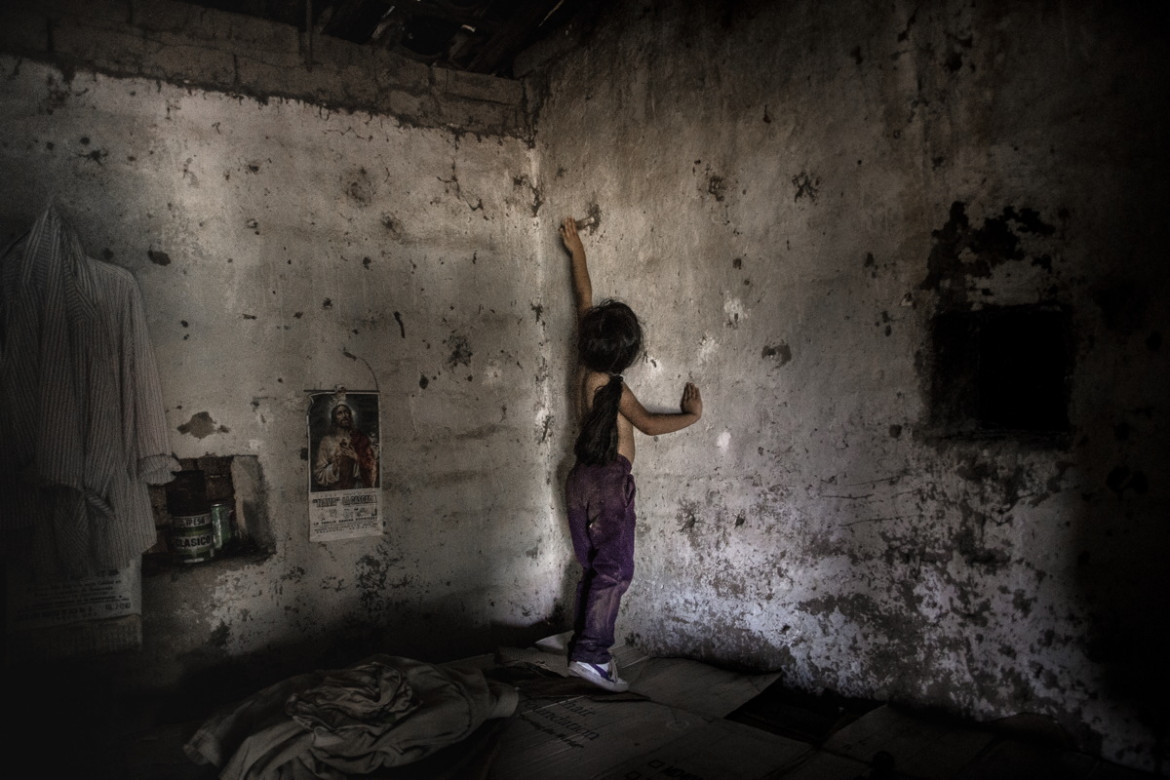 fot. Yael Martínez, "The House That Bleeds", 2. miejsce w kategorii Long Term Projects.
W Meksyku ponad ponad 37 tys. osób uważanych jest za zaginione. Większość z nich prawdopodobnie nie żyje. To ofiary niekończącej się przemocy, która od 2006 roku zabrała już ponad 250 tys. istnień ludzkich. Zniknięcia tę są powodem traumy w rodzinach zaginionych.
Przemoc ma swoje korzenie w wojnie z kartelami narkotykowymi, która w latach 2006-2012 prowadzona była przez prezydenta Felipe Calderona i która kontynuowana jest przez jego następcę. Rosnąca przemoc doprowadziły do drastycznego wzrostu liczby morderstw, zniknięć i rozwoju korupcji. Prezydent Nieto obiecał skończyć z przemocą, jednak choć liczba morderstw zmalała władze nie potrafią zrobić wiele w walce przeciwko kartelom.
W 2013 roku szwagier fotografa został zamordowany, a dwóch innych zaginęło. W związku z tym zaczął on dokumentować będący tego skutkiem rozpad emocjonalny swojej rodziny i innych rodzin dotkniętych tym problemem.