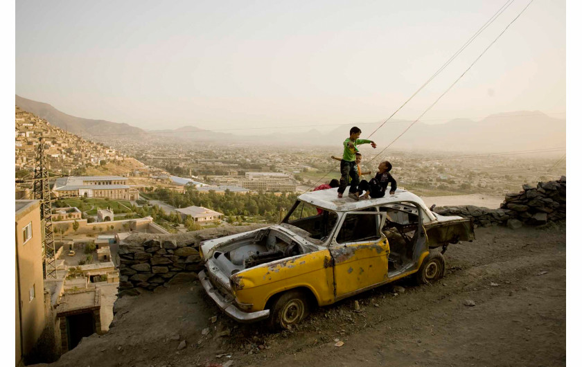 fot. Moe Zoyari | Dzieci bawią się na dachu starego samochodu w Kabulu, w Afganistanie.