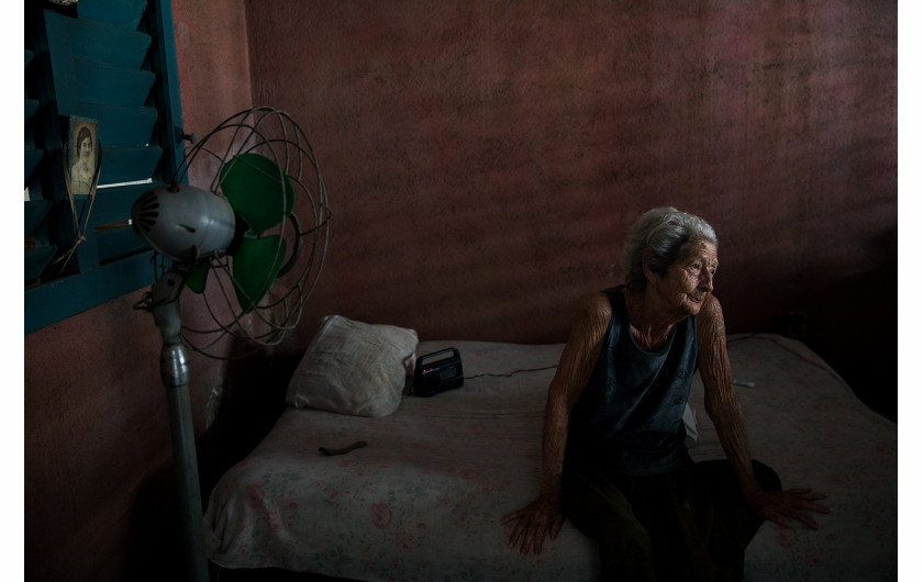 fot. Oded Wagenstein, Tereza Boniza w swoim domu, Cienfuegos, Kuba, Grudzień 2016. Na ścianie (po lewej) wisi zdjęcie jej matki z czasów młodości. Myślę, że bycie optymistą wychodzi ci na lepsze, gdy stajesz się coraz starszy, powiedziała mi, jakby czuła potrzebę zachęcenia mnie. - Ale ostatnio uważam, że to trudne.
