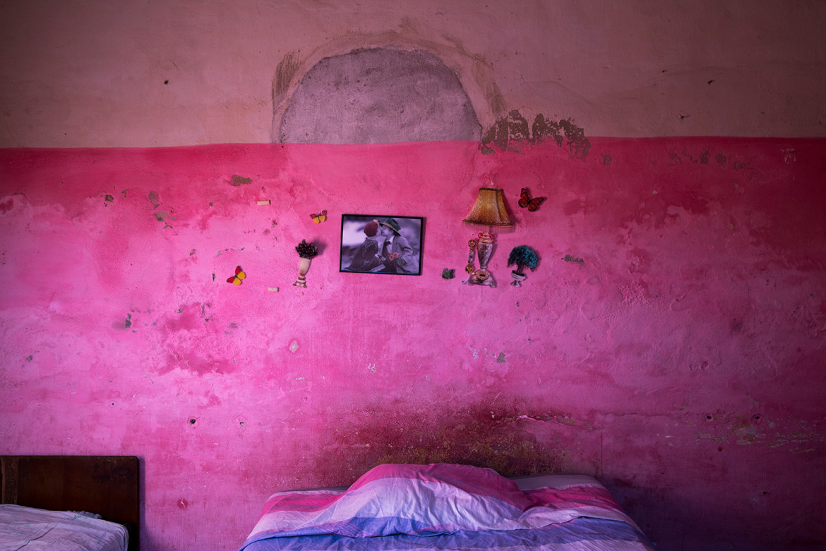 fot. Oded Wagenstein, Kolorowe przedmioty przyklejone na ścianie w jednopokojowych mieszkaniu starzejącej się społeczności, Cienfuegos, Kuba, Grudzień 2016. Kiedy umiera najemca, samorząd lokuje w mieszkaniu innego dzierżawcę i maluje ściany na nowo.