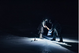 fot. Dagmara Wojtanowicz / Decade of Change<br></br><br></br>
Grupa naukowców poszukujące życia w lodzie podczas nocy polarnej w rejonie Ny-Ålesund na Svalbardzie. Arktyka ociepla się w odpowiedzi na zmiany klimatyczne, a skutki ocieplenia są odczuwalne przez mikroorganizmy - powodując zmiany w adaptacji, kolonizacji i przetrwaniu drobnoustrojów w  systemach arktycznych. Drobnoustroje mogą również wpływać na ekosystemy w dolnym biegu rzeki, a nawet na klimat, m.in. ze względu na ich zdolność do rozmnażania się i napędzania reakcji biogeochemicznych (w tym fotochemii). Wciąż istnieje wiele otwartych pytań: skąd się biorą te mikroorganizmy? Czego używają jako pożywienia? Jakich mechanizmów obronnych i strategii przetrwania używają? Jak te organizmy znoszą długą noc polarną?